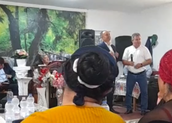 VIDEO. Înregistrări halucinante cu primarul de Ineu în campanie la biserica din colonia de rromi. Spune că Morna, contracandidatul său va trimite milițienii să-i băge în lagăre. „Eu trec pe lângă voi, nu vă ascult, îmi rupeți un picior, nu-i bai…Ne și înjurăm, ne și certăm, dar ne împăcăm.. M-au sunat românii din Botean: Știți ce zic români: domn primar, o zis că sunteți cu țâganii…Nu mi-e rușine, eu știu limba țâgănească, o și vorbesc pretutindeni…Vin să vă cumpere pe un kil de ulei…Ori te duci cu ăla ca mine și care nu-i nici 100% la cap si vă oferă ajutor la orice oră, ori cu ăla care vine cu dronele” 